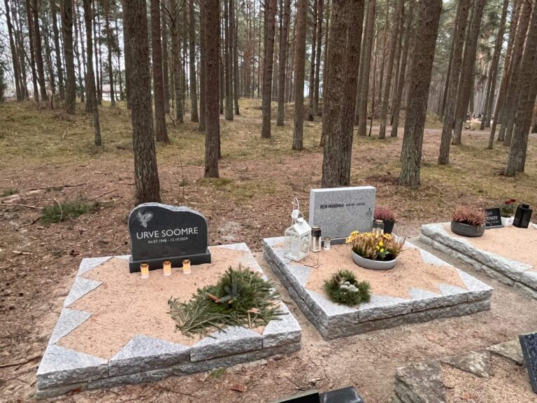 Pärnamäe kalmistu OÜ poolt valmistatud klombitud graniidist hauapiirded koos küünalde ja kaunistustega haual.