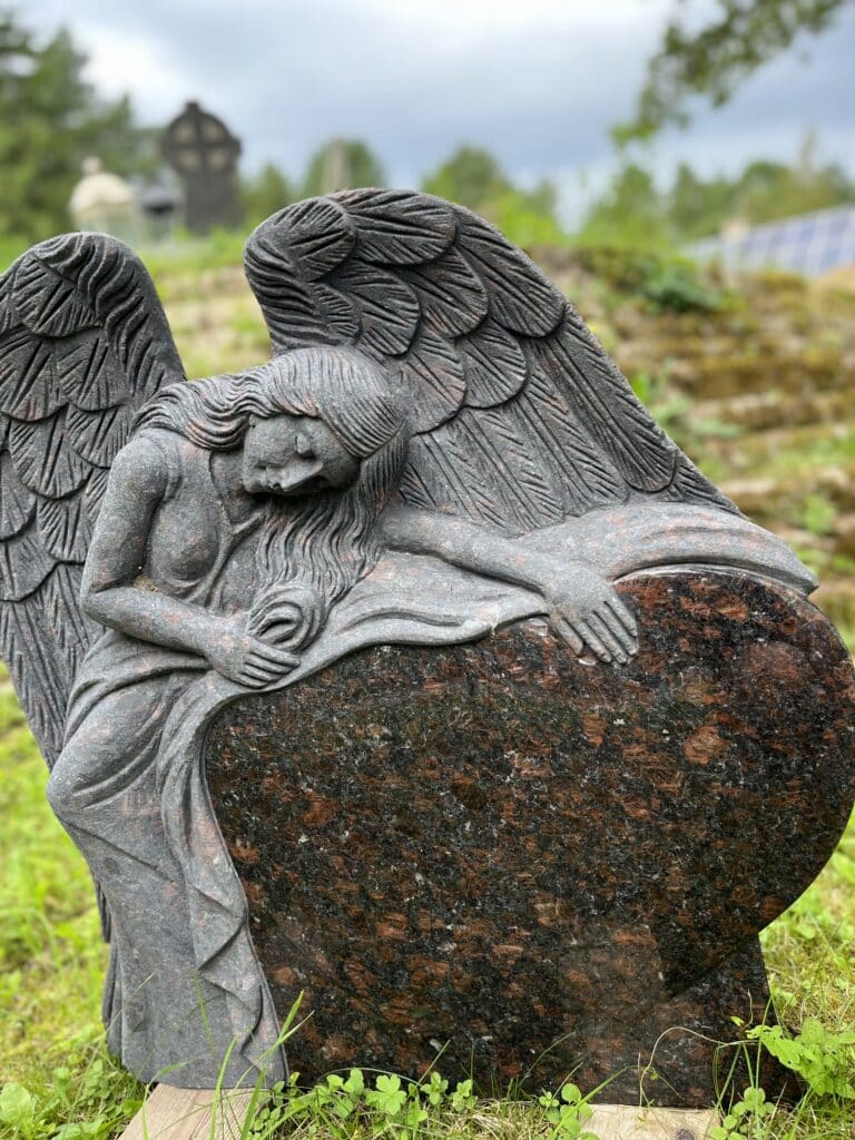 Pildil on südamekujuline hauakivi koos ingliga, mis viib sind hauakivide kategooriasse
